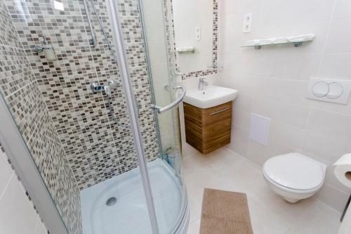 a bathroom with a shower and a toilet and a sink at Boutique Residence Jokai - Apartment in the city center in Budapest