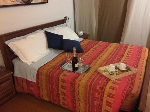 a bed with a bottle of wine on top of it at VillaRosa in Santa Lucia di Piave