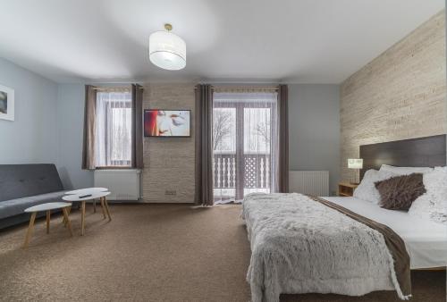 a bedroom with a large bed and a couch at Nefryt - 600 m od PKP, duży parking, lodówka, czajnik, balkon, in Karpacz