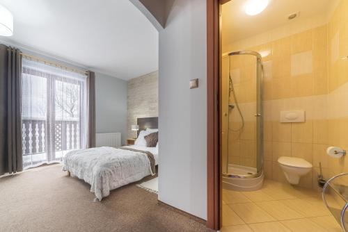 a bedroom with a bed and a shower and a toilet at Nefryt - lodówka i czajnik w pokoju, dwa aneksy kuchenne ogólnodostępne, duży parking in Karpacz