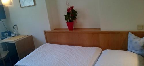 a bedroom with a bed and a vase with a plant at Hotel zum goldenen Hirschen in Göstling an der Ybbs