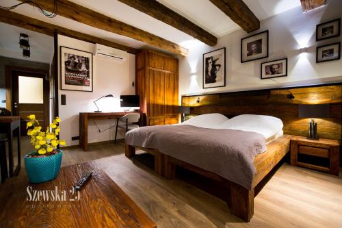 a bedroom with a large bed and a desk at Apartamenty Szewska 25 in Toruń
