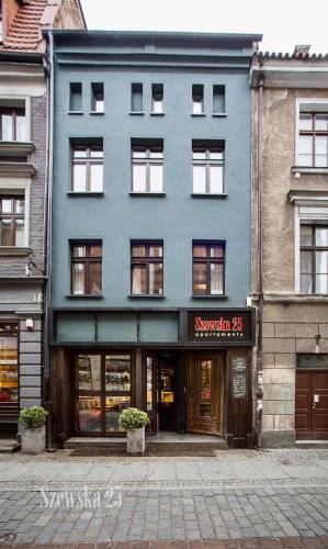 a blue building with a sign in front of it at Apartamenty Szewska 25 in Toruń