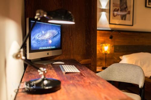a computer monitor sitting on a wooden desk in a room at Apartamenty Szewska 25 in Toruń