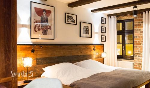 a bedroom with a bed and a poster on the wall at Apartamenty Szewska 25 in Toruń