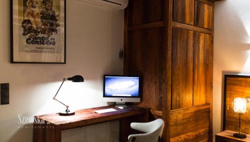 a room with a desk with a computer on it at Apartamenty Szewska 25 in Toruń