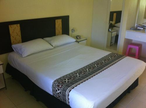 a bedroom with a large white bed in a room at Grand West Villas in Nadi