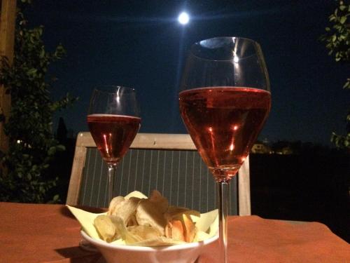 two glasses of wine and a bowl of food on a table at VillaRosa in Santa Lucia di Piave