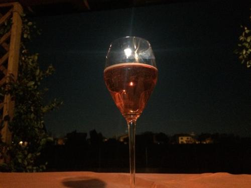 a glass of wine sitting on a table at night at VillaRosa in Santa Lucia di Piave