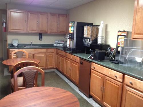 a kitchen with wooden cabinets and a table and a counter at Howard Johnson by Wyndham Gillette in Gillette