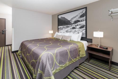 a hotel room with a bed and a picture on the wall at Super 8 by Wyndham Kalispell Glacier National Park in Kalispell