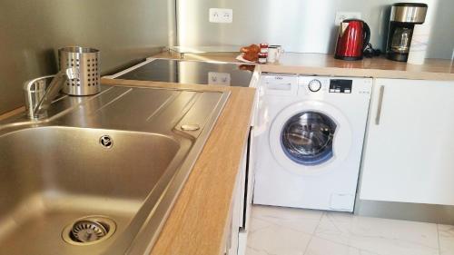 une cuisine avec un évier et une machine à laver dans l'établissement Le De Gaulle, à Antibes