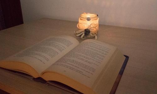 an open book on a table next to a lamp at VillaRosa in Santa Lucia di Piave