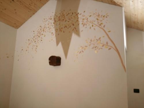 a wall with a tree stenciled on it at La Corte B&B in Candiolo