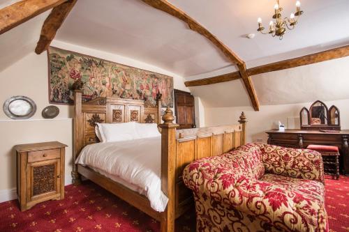 a bedroom with a bed and a chair and a piano at Appleby Castle in Appleby