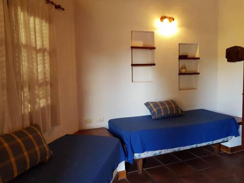 1 dormitorio con 2 camas, ventana y estanterías en Apart Santander, en Mina Clavero