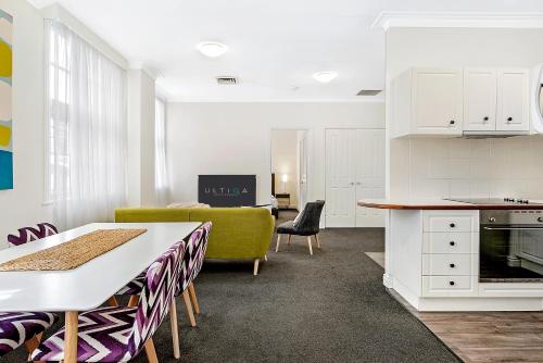 eine Küche und ein Wohnzimmer mit einem Sofa und einem Tisch in der Unterkunft ULTIQA Rothbury Hotel in Brisbane