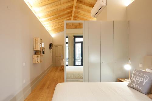 a bedroom with a white bed and a white cabinet at LOFT Sá de Noronha in Porto