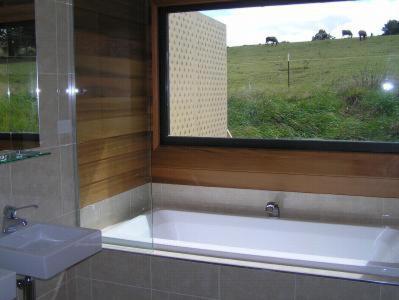 baño con bañera y ventana en Gooromon Park Cottages, Canberra, en Hall