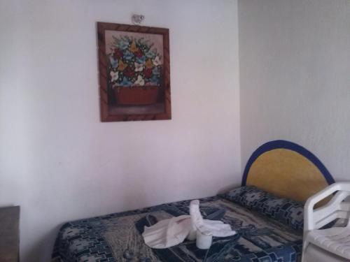 a room with a bed and a picture on the wall at Hotel Y Bungalows Islas Careyes in Los Ayala