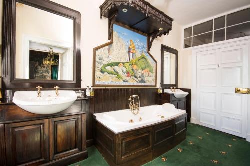 bagno con vasca, lavandino e specchio di Appleby Castle ad Appleby