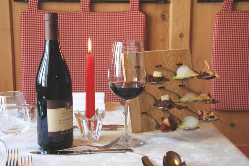 a bottle of wine sitting on a table with wine glasses at Hotel Gran Mugon in Vigo di Fassa