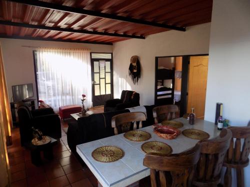 a dining room and living room with a table and chairs at Cabañas Refugio del cerro in Aquitania