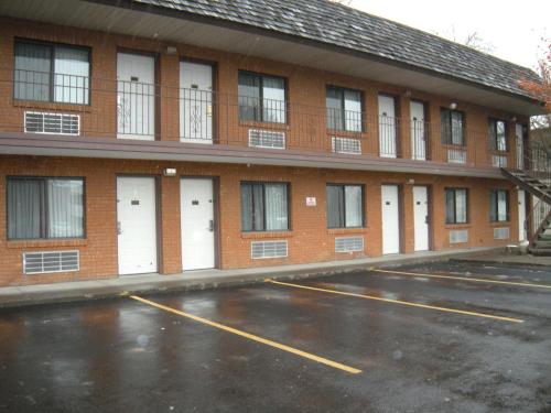 a parking lot in front of a building with white doors at Motel West in Idaho Falls