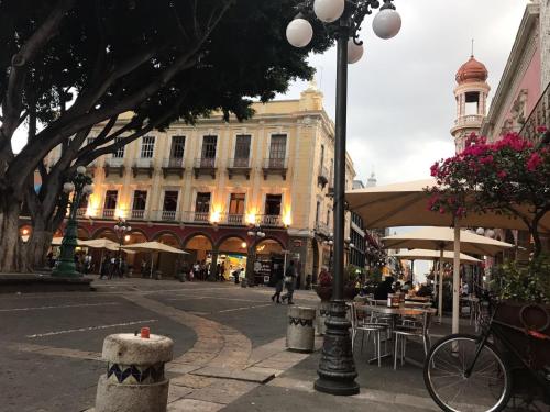 una via cittadina con tavoli e sedie e un edificio di Zocalo SUPER VISTA a Puebla