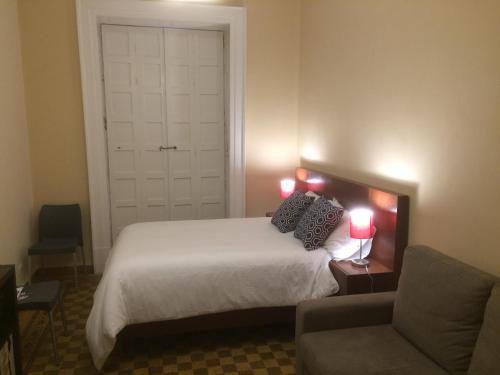 a bedroom with a bed and a chair and two lamps at Zocalo SUPER VISTA in Puebla