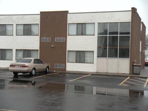 a car parked in a parking lot in front of a building at Motel West in Idaho Falls