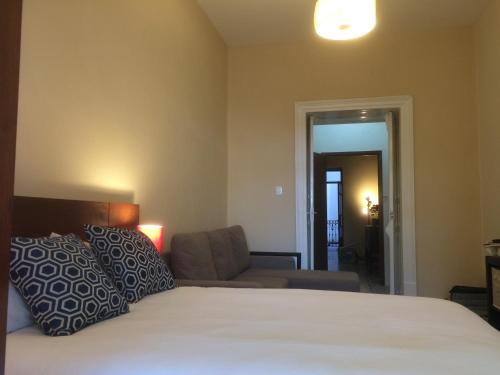 a bedroom with a large bed and a couch at Zocalo SUPER VISTA in Puebla