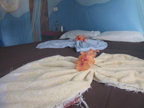 two beds with towels and flowers on top of them at Rosa's Lake Cabins in Mérida