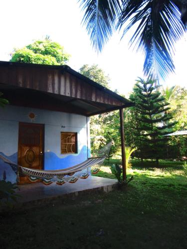 a hammock in front of a small house at Rosa's Lake Cabins in Mérida