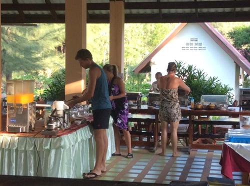 een groep mensen die rond een tafel met een blender staan bij Gooddays Lanta Beach Resort SHA in Koh Lanta
