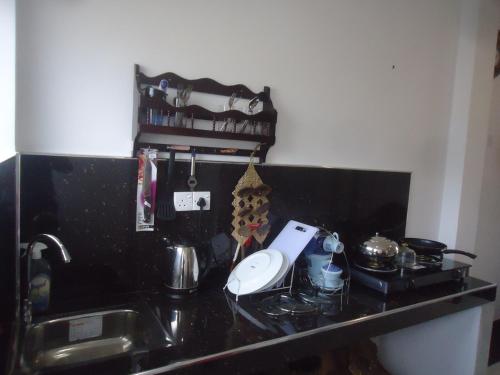 a black counter top with a sink and a mixer at Sun & Moon Good View Villa in Unawatuna