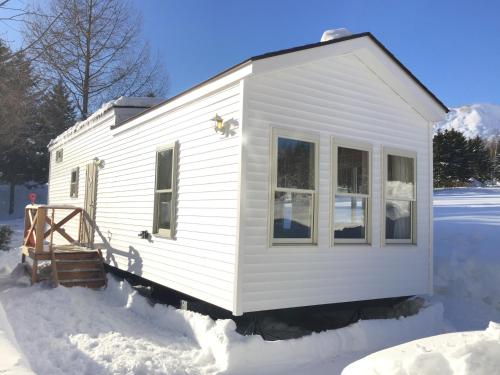 a white tiny house sitting in the snow at Rusutsu Pension Clydesdale in Rusutsu