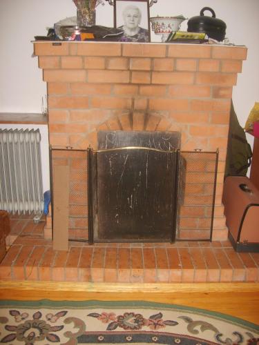 a brick fireplace with a black door on it at Guest House Svetlana in Gori