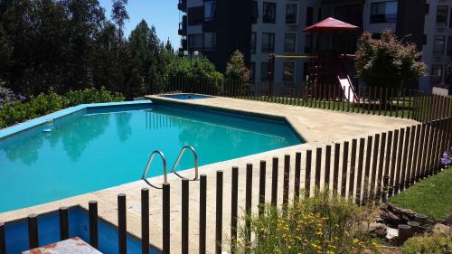 a swimming pool with a fence around it at Vista Laguna in San Pedro de la Paz