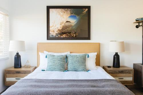 a bedroom with a bed with two night stands and two lamps at Surfhouse in Encinitas