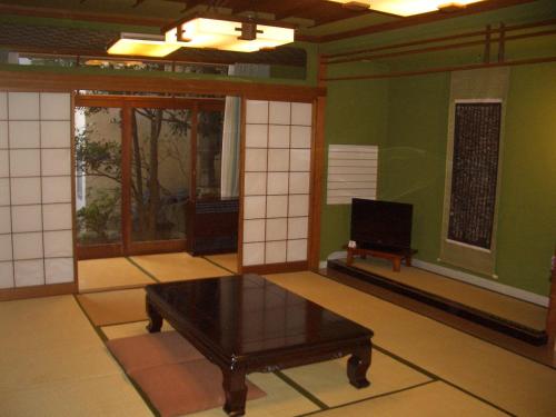 a living room with a table and a tv in it at Murataya in Kanazawa