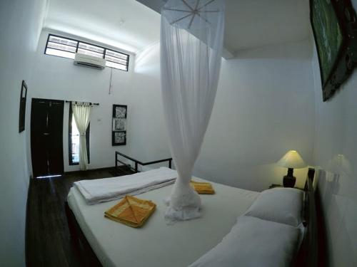 a bedroom with two beds and a window at Tirta Yoga Inn in Padangbai