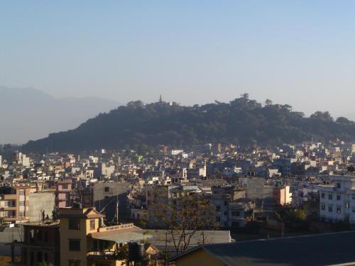a view of a city with a hill in the background at SUBI Home Stay in Kathmandu