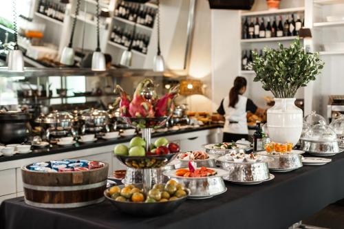 a kitchen with a buffet of food on a table at BYD Lofts - Boutique Hotel & Serviced Apartments - Patong Beach, Phuket in Patong Beach