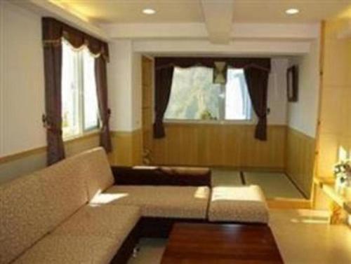 a living room with a couch and a window at Gau Shan Ching Hotel in Zhongzheng