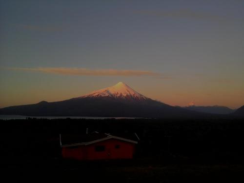 a mountain in the distance with a red house and a building at Topahue in Ensenada