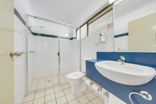 ein Bad mit einem Waschbecken und einer Dusche in der Unterkunft Gladstone Palms Motor Inn in Gladstone