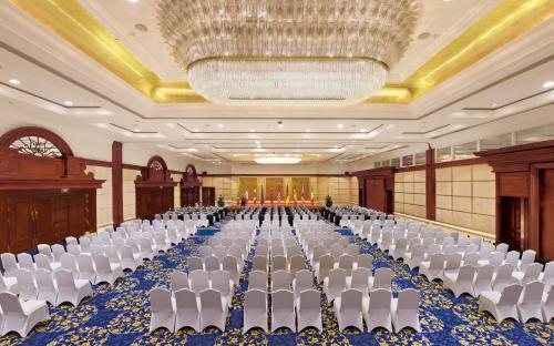 a banquet hall with white chairs and a chandelier at The Presidential Beijing in Beijing