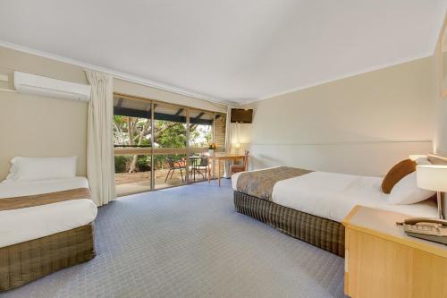 מיטה או מיטות בחדר ב-Gladstone Palms Motor Inn