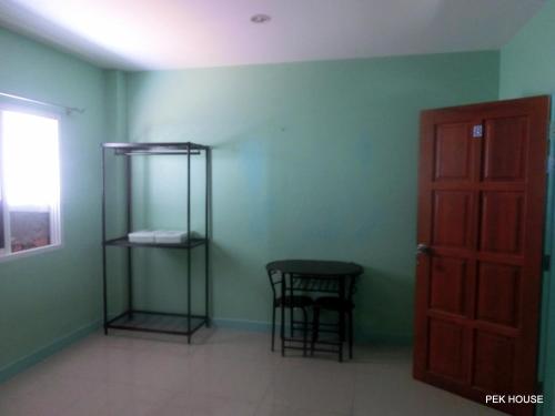 a room with a table and chairs and a door at Pek House in Phuket Town